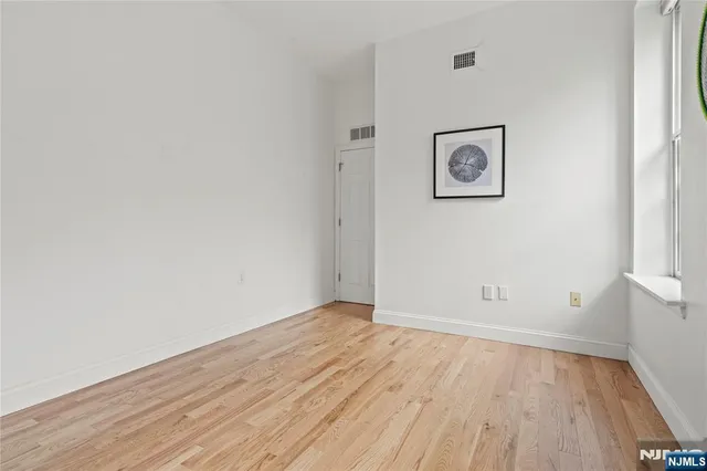 a view of a room with wooden floor and white walls