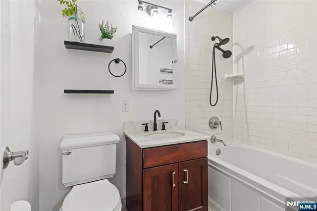 a bathroom with a sink vanity mirror and toilet