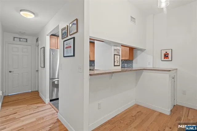a view of a hallway with wooden floor and cabinet