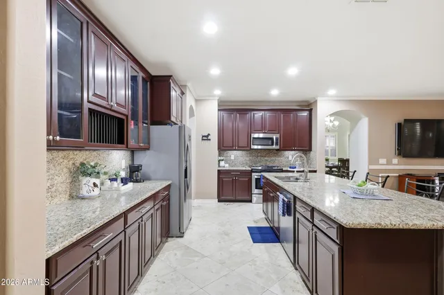 a kitchen with stainless steel appliances granite countertop a sink stove and refrigerator