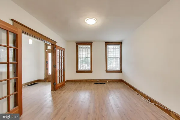 an empty room with wooden floor and windows