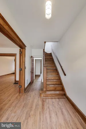 a view of a hallway with wooden floor and staircase