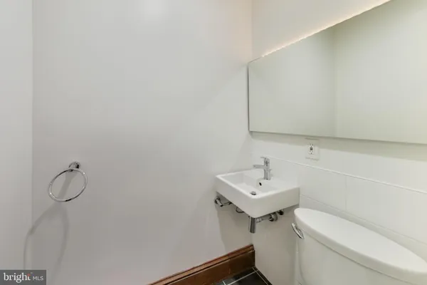 a bathroom with a sink toilet and a mirror
