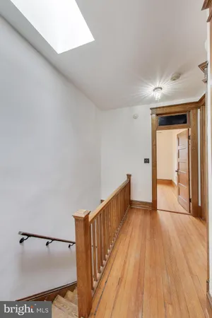 a view of a hallway with wooden floor and staircase