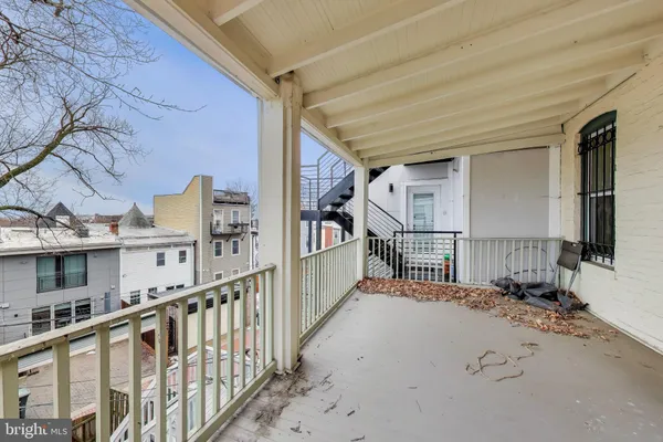 an empty room with wooden floor chandelier fan and windows