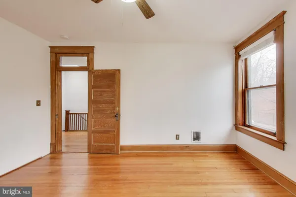 a view of a room with wooden floor and ceiling fan