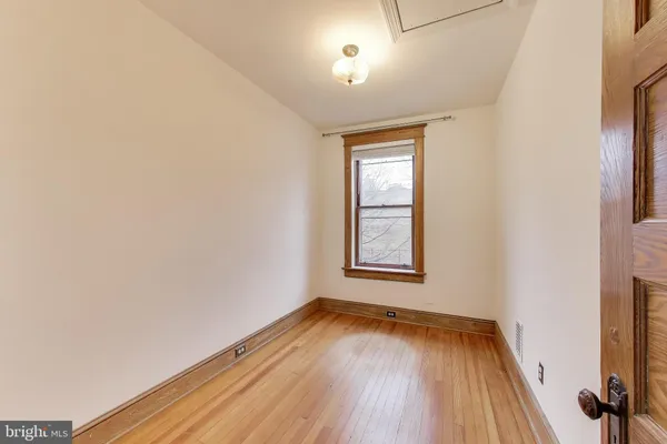 a view of a room with wooden floor and a ceiling fan