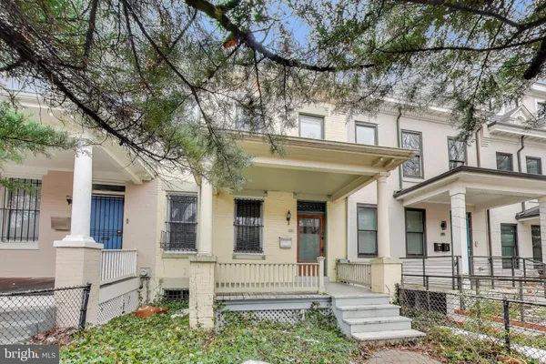 a view of a white house with large windows and a tree