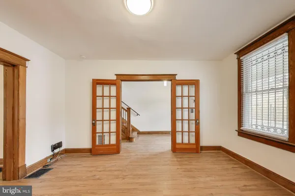 an empty room with wooden floor and windows