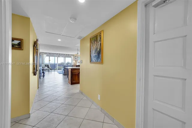 a view of a hallway with a dining table and chandelier