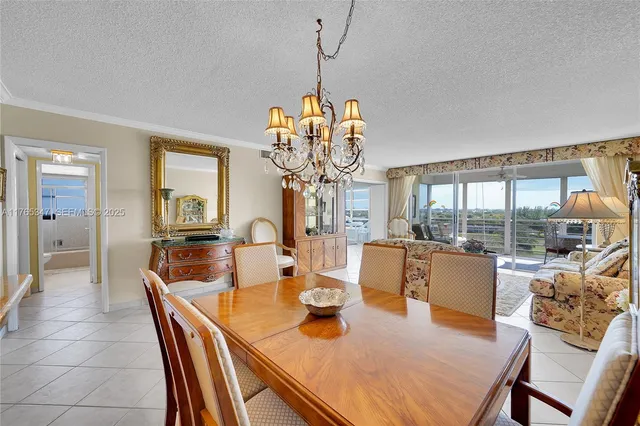 a dining room with furniture a chandelier and wooden floor
