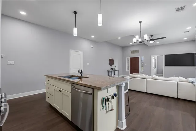 a view of living room with granite countertop furniture a flat screen tv and kitchen view