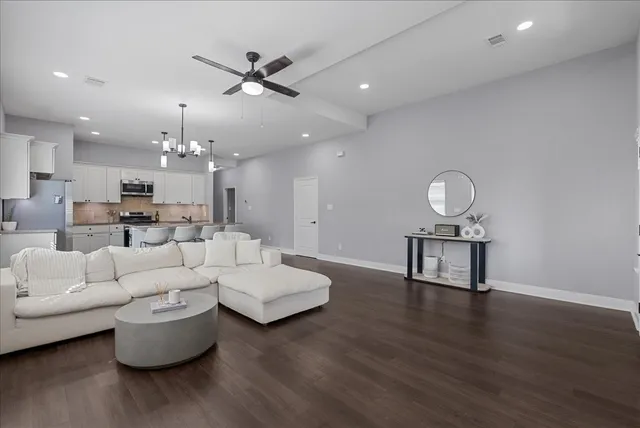 a living room with furniture and a wooden floor