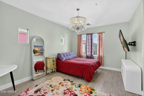 a bedroom with a bed and a chandelier