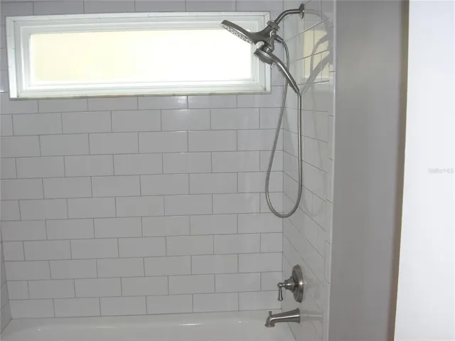 a bathroom with a granite countertop sink a toilet a mirror and bathtub