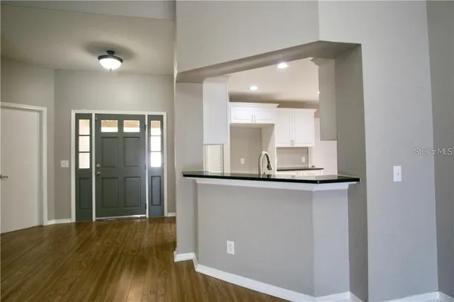 a kitchen with granite countertop a sink and a refrigerator