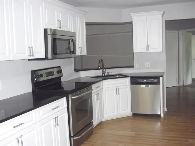 a kitchen with white cabinets and white appliances