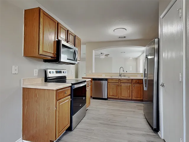 a kitchen with stainless steel appliances granite countertop a stove a sink and a refrigerator