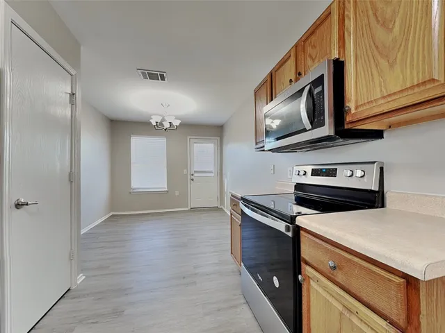 a kitchen with stainless steel appliances granite countertop a stove a microwave and refrigerator