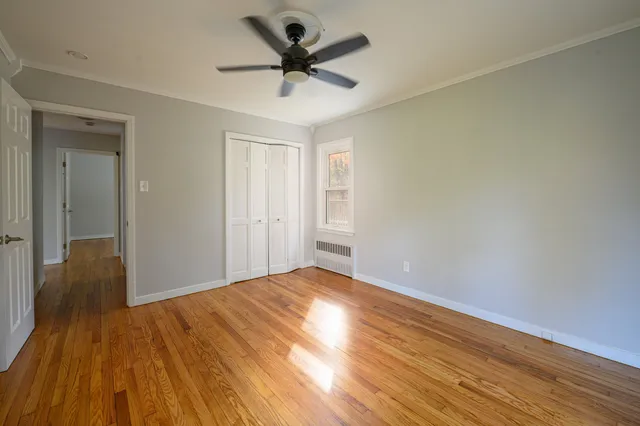 a view of a big room with wooden floor and a ceiling fan