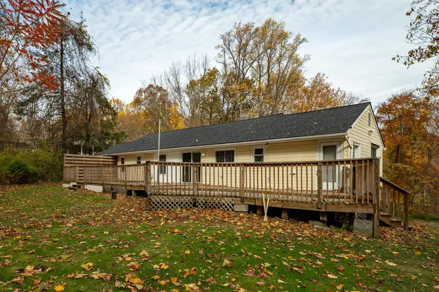 a white house that has a small yard and wooden fence