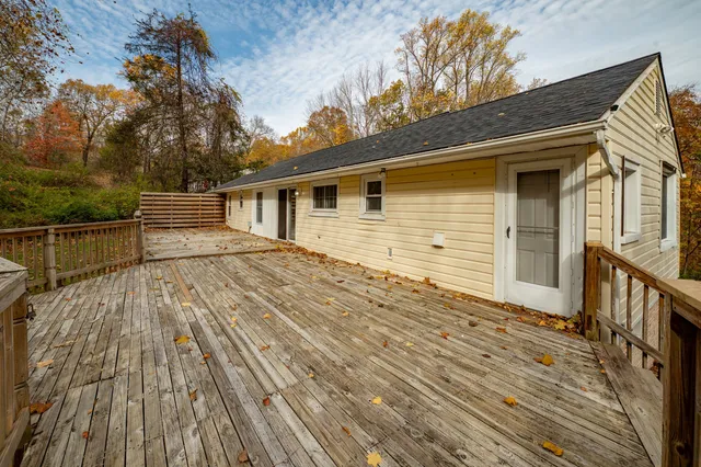 a view of house with deck and wooden floor