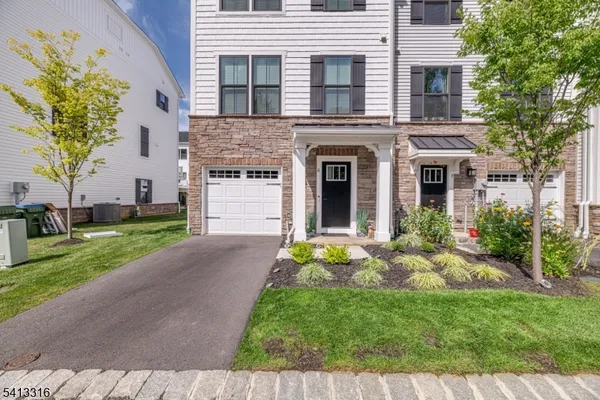 a front view of a house with a garden and plants