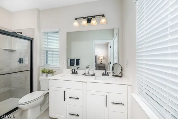 a bathroom with a double vanity sink toilet and shower
