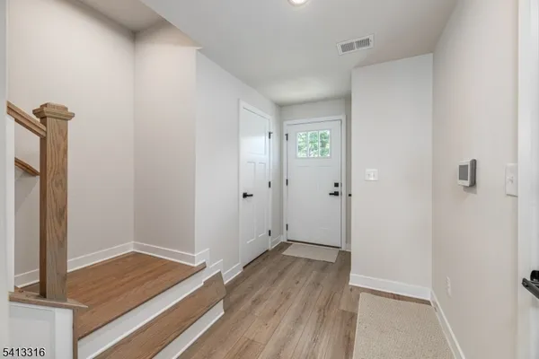 a view of room with walk in closet and wooden floor