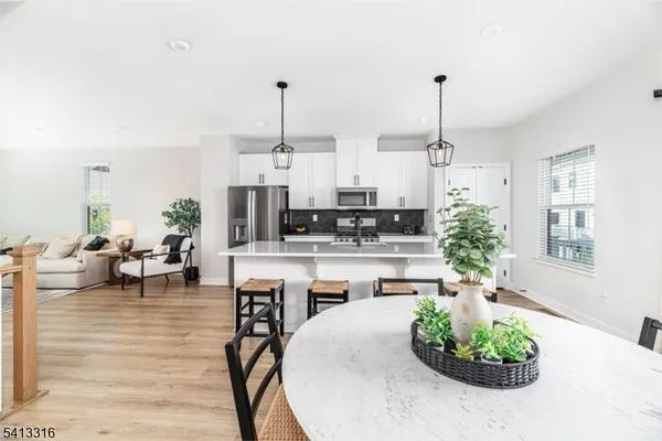 a room with stainless steel appliances kitchen island granite countertop furniture and a view of living room