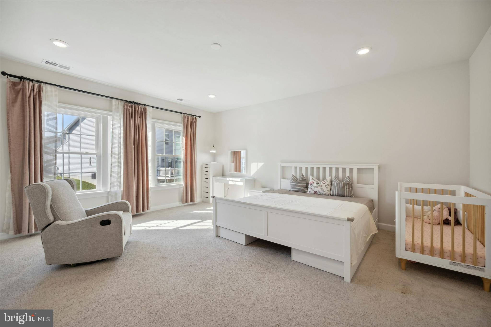 831 Stonecliffe Road Malvern, PA 19355 - Photo 13 of 32 a spacious bedroom with a bed and a couch with window