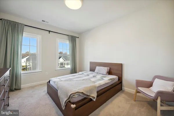a large bed sitting in a bedroom next to a window