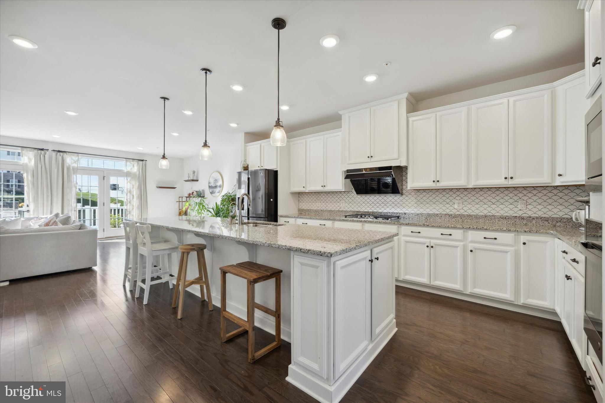 831 Stonecliffe Road Malvern, PA 19355 - Photo 4 of 32 a kitchen with stainless steel appliances granite countertop a sink a stove a refrigerator and white cabinets with wooden floor