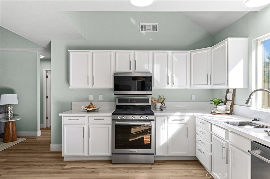 1572 Arch Way Chico, CA 95973 - Photo 10 of 43 a kitchen with cabinets stainless steel appliances a sink and wooden floor