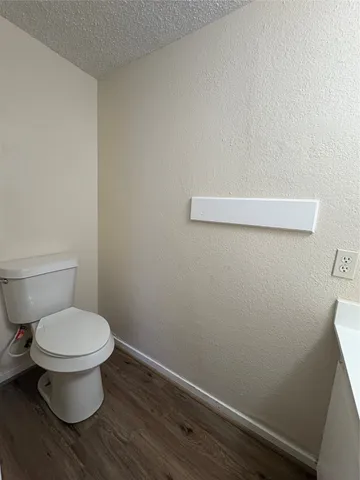 a toilet sitting in a bathroom next to a wooden wall