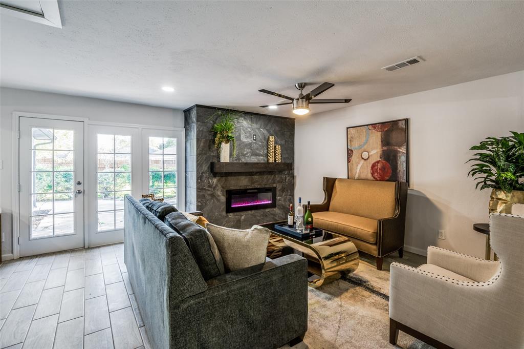 6000 Blue Ridge Trail Plano, TX 75023 - Photo 6 of 25 Living room with a large fireplace, ceiling fan, a textured ceiling, and french doors
