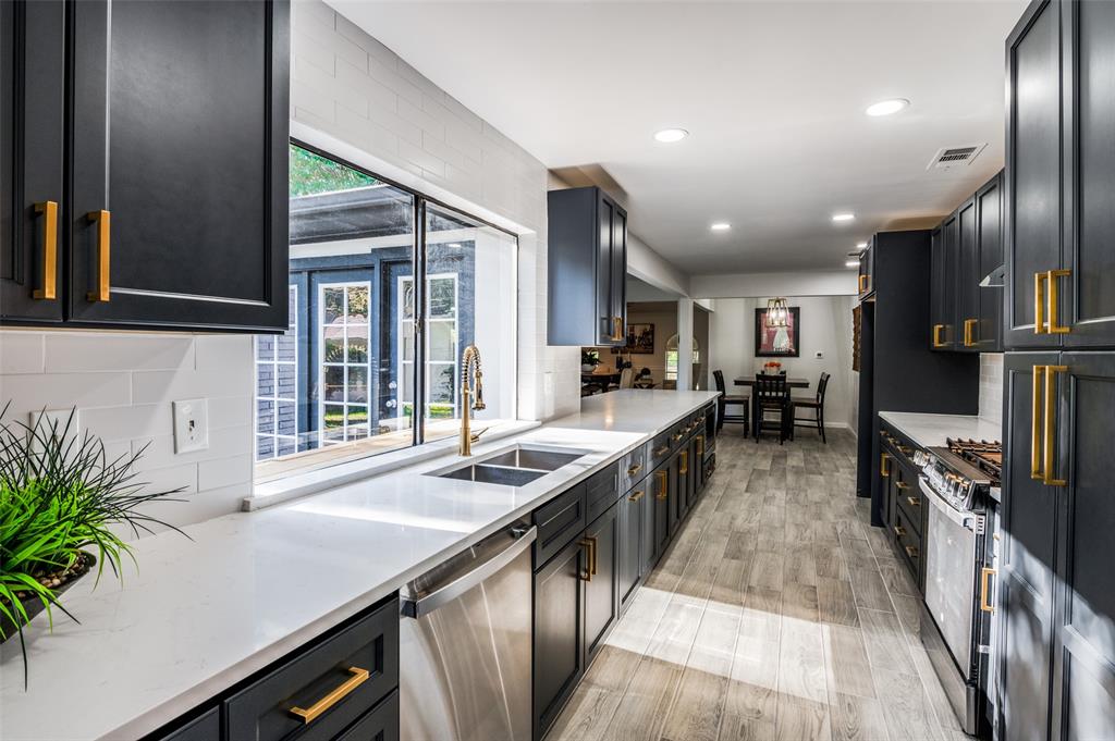 6000 Blue Ridge Trail Plano, TX 75023 - Photo 9 of 25 Kitchen with tasteful backsplash, light stone countertops, stainless steel appliances, recessed lighting, and dark cabinetry