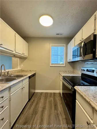 a kitchen that has a sink and a stove top oven