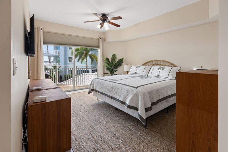 275 Northwest Flagler Avenue, Unit 205 Stuart, FL 34994 - Photo 11 of 43 a bedroom with a bed lamp and a large window