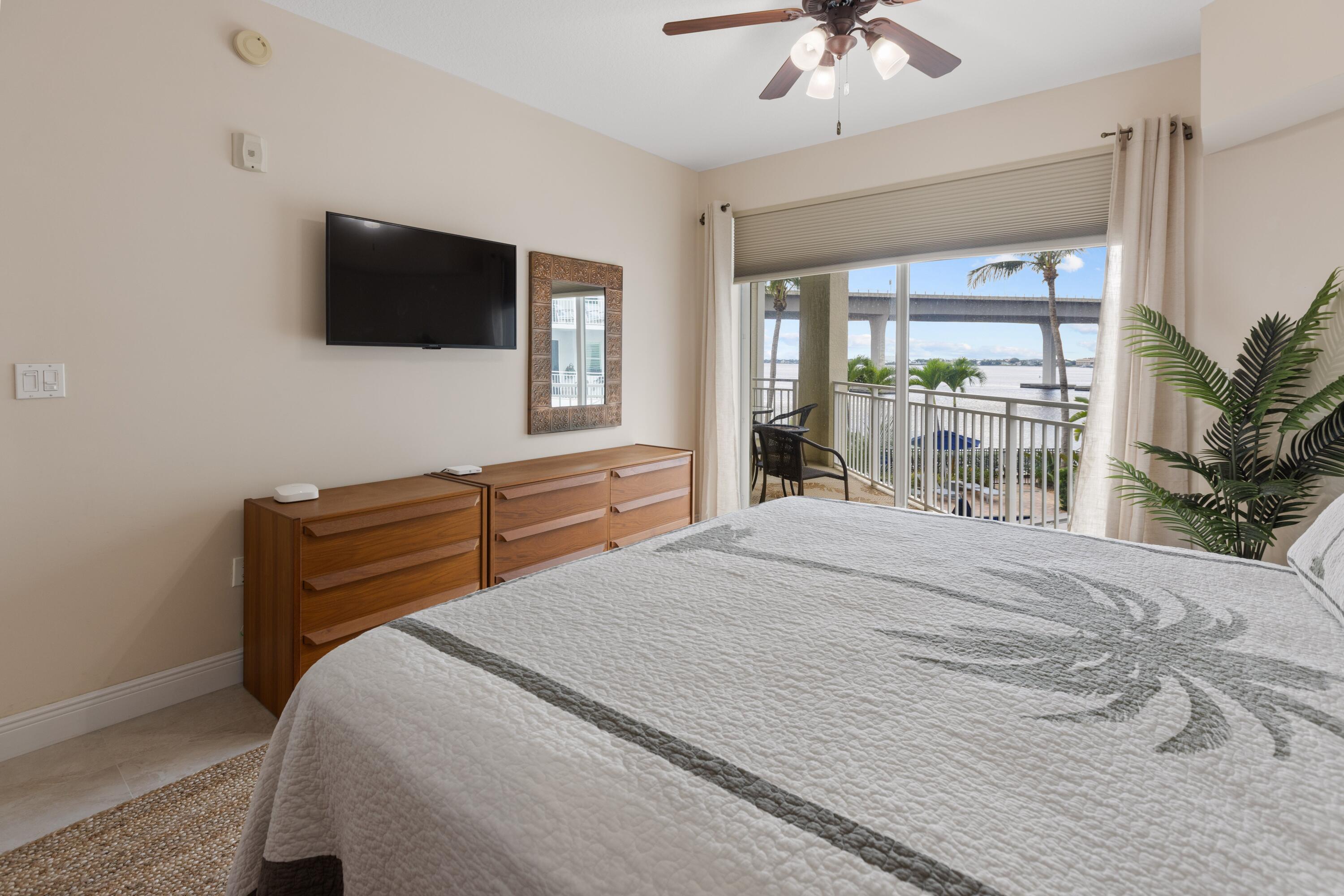 275 Northwest Flagler Avenue, Unit 205 Stuart, FL 34994 - Photo 12 of 43 a bedroom with a bed and a flat screen tv