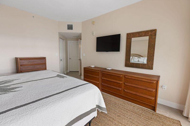 275 Northwest Flagler Avenue, Unit 205 Stuart, FL 34994 - Photo 13 of 43 a bedroom with a bed and a flat screen tv