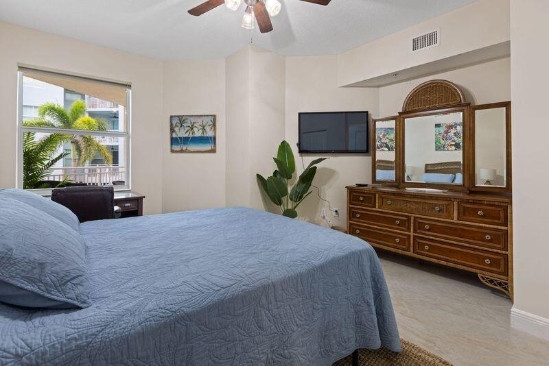 275 Northwest Flagler Avenue, Unit 205 Stuart, FL 34994 - Photo 19 of 43 a bedroom with a bed and a dresser next to a window