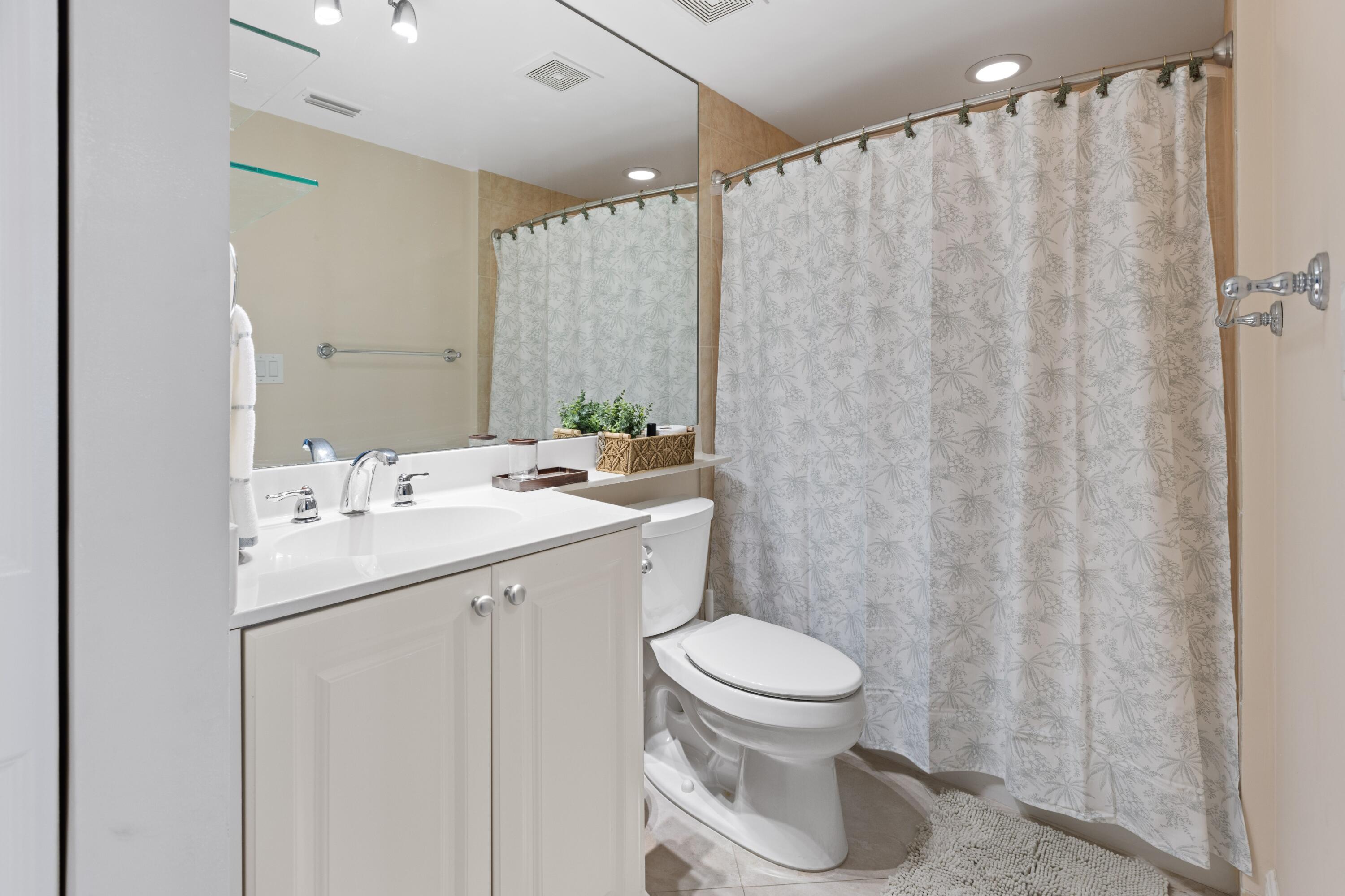 275 Northwest Flagler Avenue, Unit 205 Stuart, FL 34994 - Photo 20 of 43 a bathroom with a sink a toilet and shower