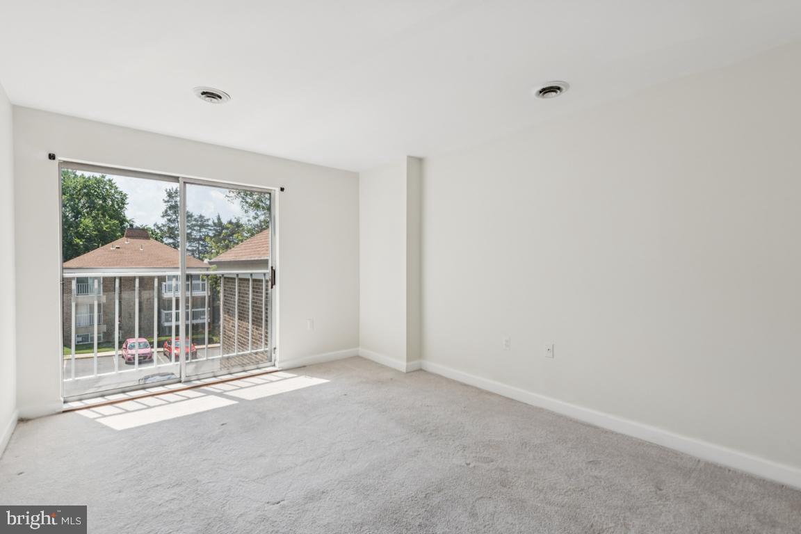 3240 Hewitt Avenue, Unit 63A Silver Spring, MD 20906 - Photo 11 of 22 an empty room with wooden floor and a floor to ceiling window