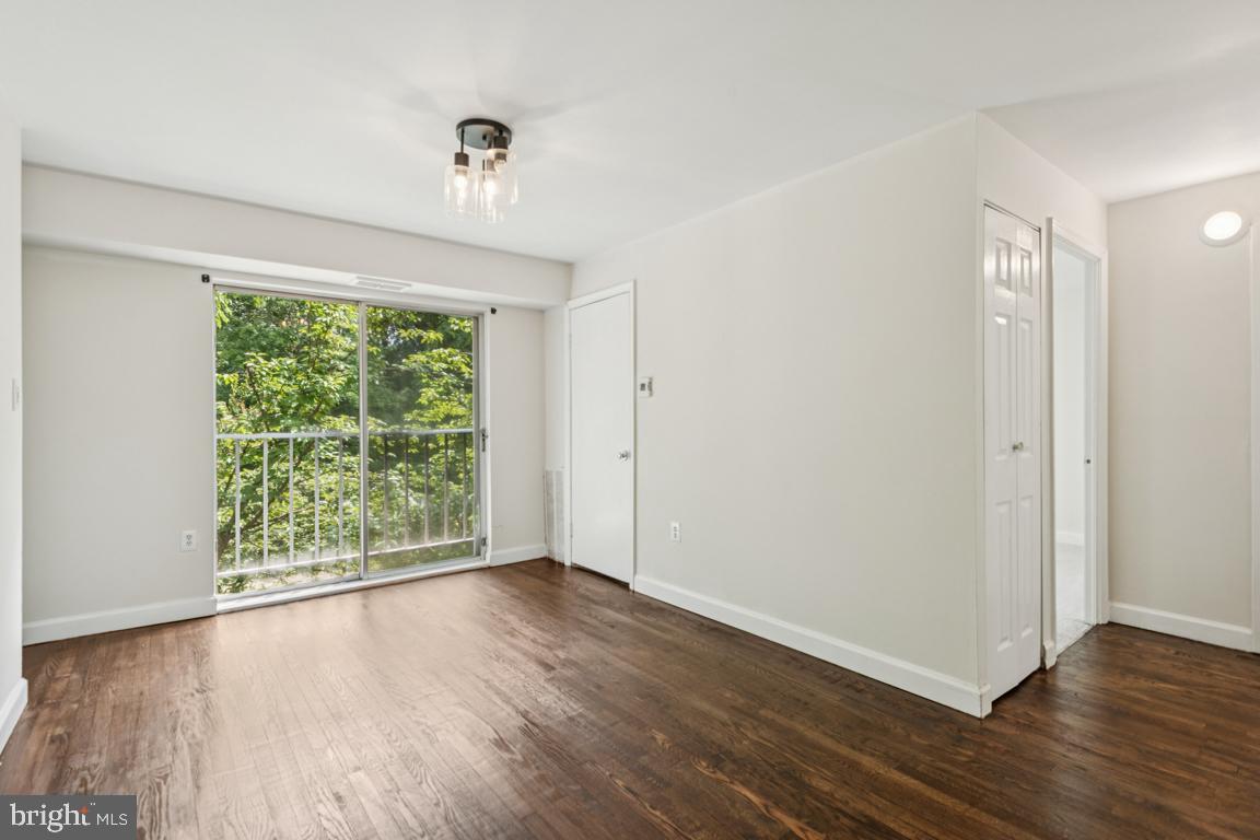 3240 Hewitt Avenue, Unit 63A Silver Spring, MD 20906 - Photo 6 of 22 a view of an empty room with wooden floor and a window