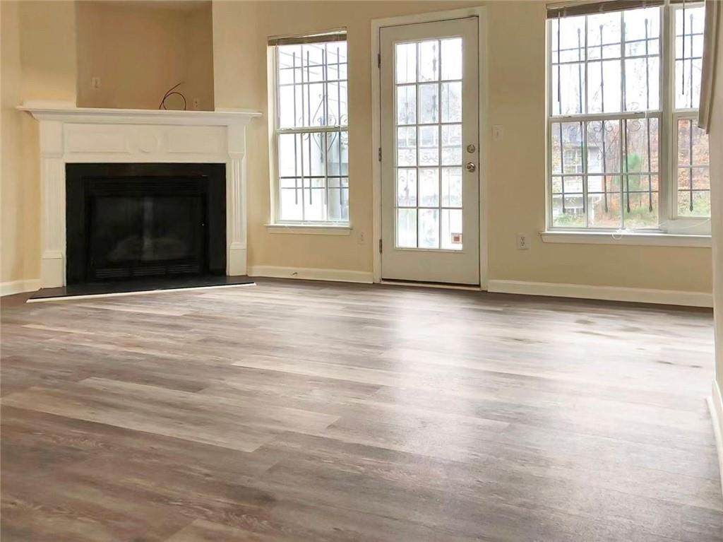 2568 Walden Lake Drive Decatur, GA 30035 - Photo 3 of 16 an empty room with wooden floor fireplace and windows