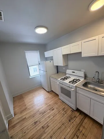 a kitchen with wooden floors and white appliances