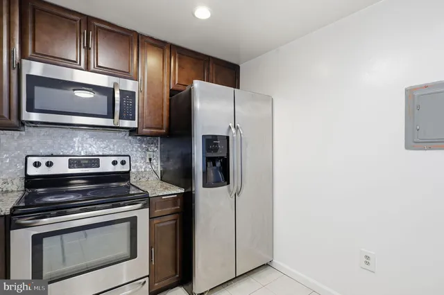 a kitchen with stainless steel appliances granite countertop a refrigerator stove and microwave