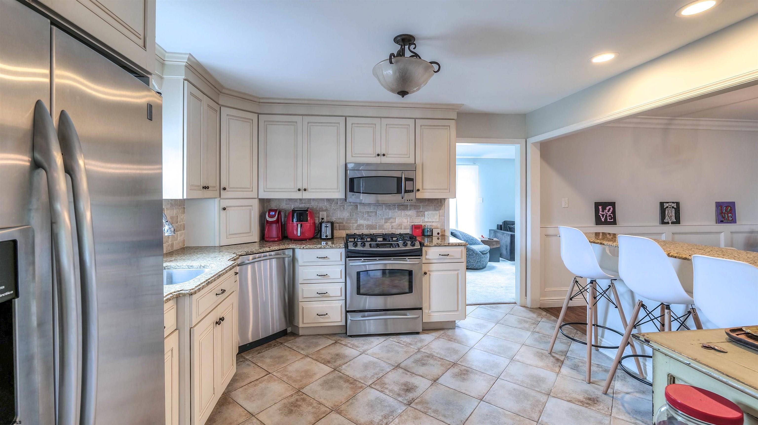 6 North Lancaster Avenue Margate City, NJ 08402 - Photo 15 of 32 a kitchen with stainless steel appliances granite countertop a stove a sink and a refrigerator