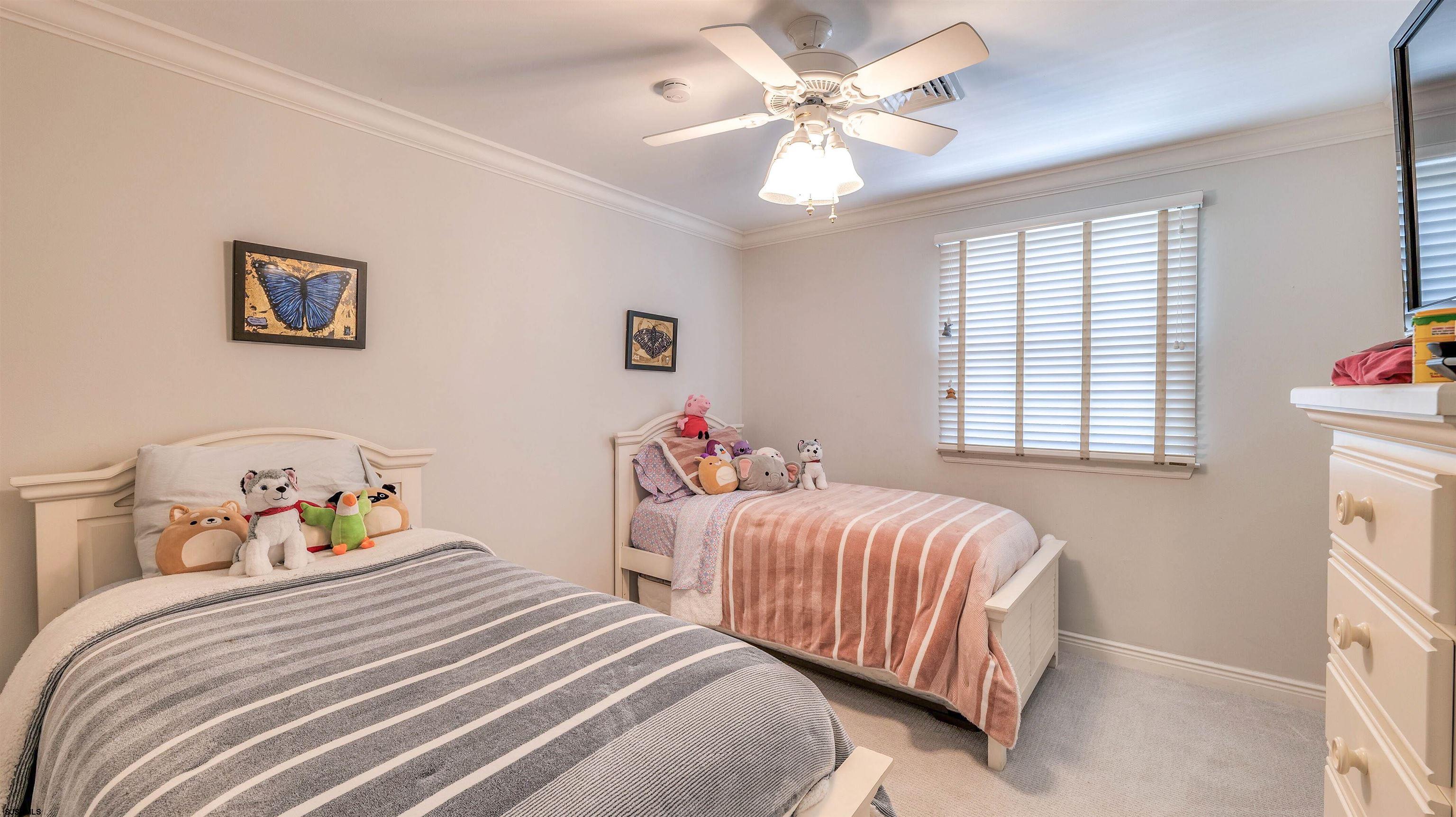 6 North Lancaster Avenue Margate City, NJ 08402 - Photo 21 of 32 a bedroom with two beds and a chandelier